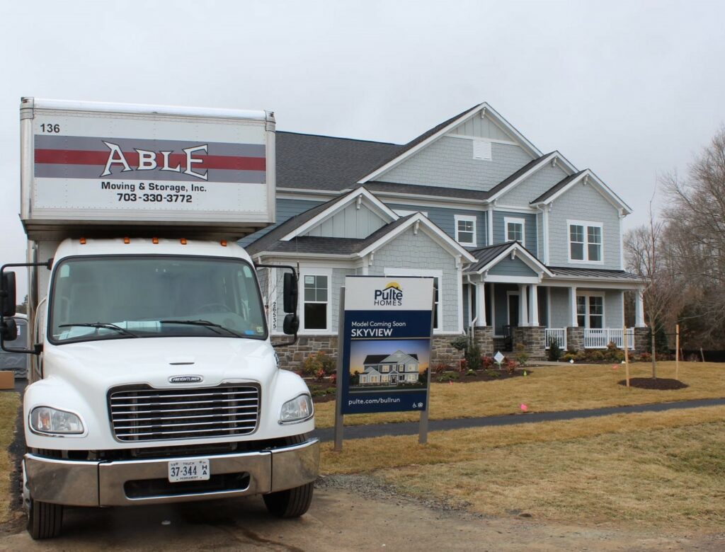 Able moving truck in front of a Model Home
